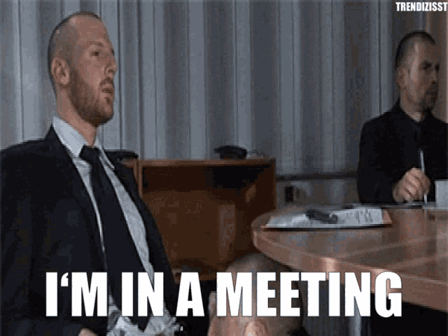 Use this professional 'in a meeting' GIF to signal your status. Download free for Slack or email notifications.
